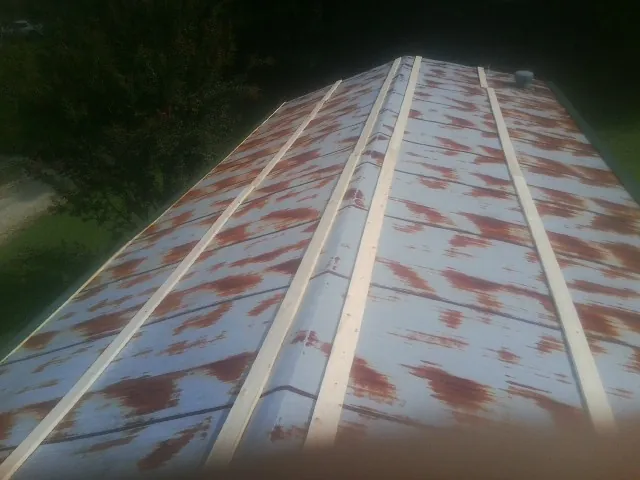 Rusted metal roof panels with new wood purlins before replacement — Storm Damage Roof Repair in Cincinnatus by Roofing Brothers